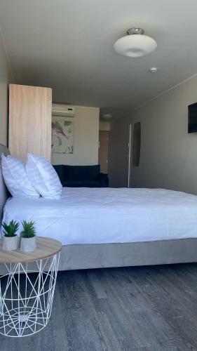 a large white bed in a room with a table at Apartement Aisa in Pärnu