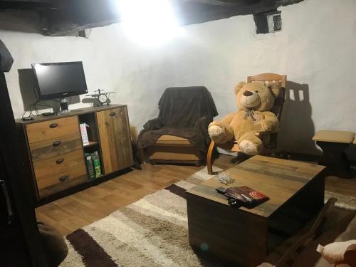 a teddy bear sitting on a chair in a living room at VILA MILICA & SPA ALEKSANDRA in Dimitrovgrad