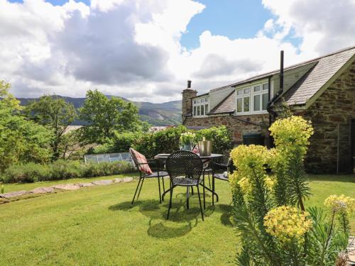a table and chairs in the yard of a house at Bodowen Coach House in Barmouth