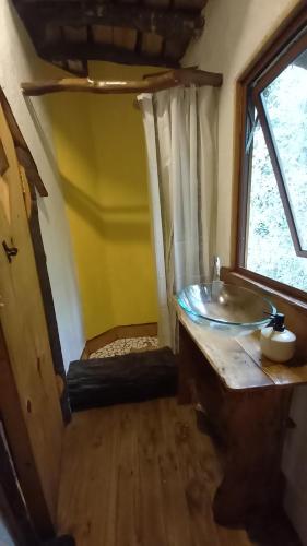 baño con lavabo y ventana en Cabañas AntuKullen, en Pucón