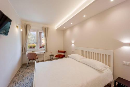 1 dormitorio con cama blanca y ventana en Gli Ulivi Rooms And Breakfast, en Andora
