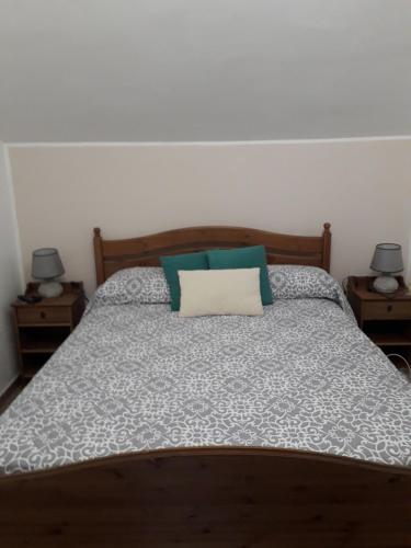 Una cama con almohadas verdes y blancas. en La casetta, en Varazze