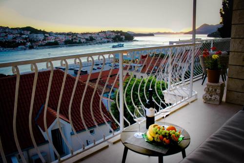 a balcony with a table with a bowl of fruit on it at Apartments Tayra in Dubrovnik