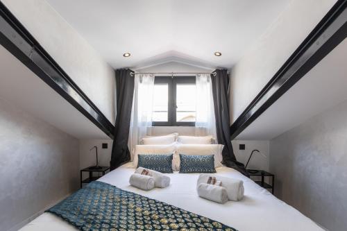 una camera da letto con un grande letto bianco con cuscini di Résidence Topaze - Central - Luxurious - 50m Croisette Palais - LRA CANNES a Cannes