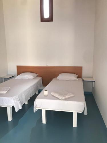 um quarto com duas camas e uma mesa em Quintal do Maio em Vila do Maio