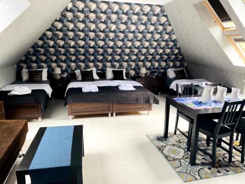 a bedroom with two beds and a large wall at Dom Supełek in Duszniki Zdrój