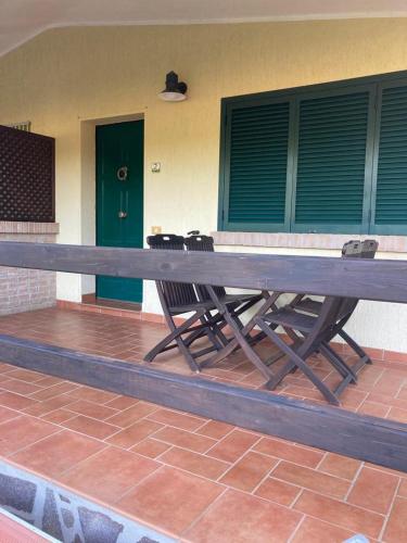 un patio con grande tavolo e sedie in legno di Appartamenti Podere 270 a Punta Ala