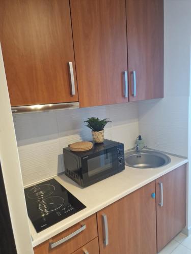 a kitchen with a microwave and a sink at Apartament Morski in Gdynia