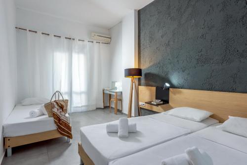 a hotel room with two beds and a chair at Azure Mare Hotel in Hersonissos