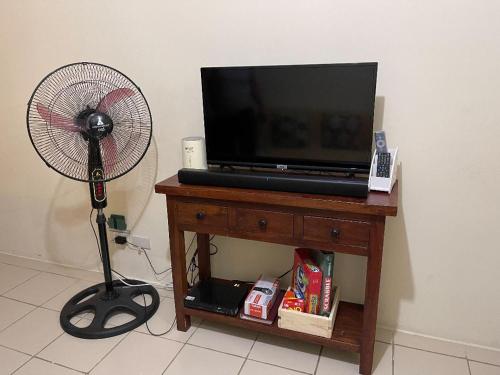 a fan and a television on a table next to a fan at Urban Deca Homes Manila Rustic Cozy Staycation in Manila