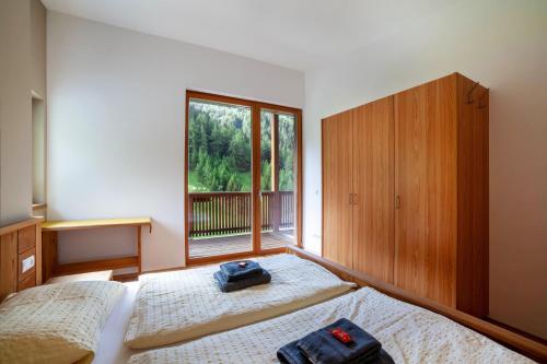 1 dormitorio con 2 camas y ventana en Pritscheshof Ferienwohnung Balkon, en Malles Venosta
