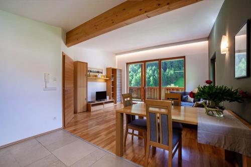 a dining room and living room with a table and chairs at Pritscheshof Ferienwohnung Balkon in Malles Venosta