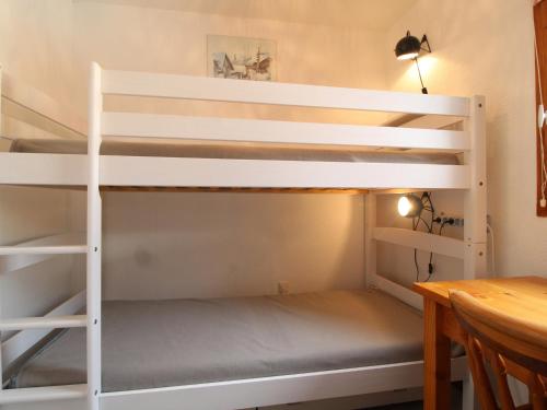 Appartement Lanslevillard, 2 pièces, 5 personnes - FR-1-508-257 في لانسليفلارد: سرير بطابقين أبيض في غرفة مع طاولة