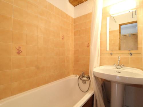 La salle de bains est pourvue d'un lavabo, de toilettes, d'une baignoire et d'un miroir. dans l'établissement Appartement 5 pers. avec balcon, proche pistes et commerces à Val Cenis Le Haut - FR-1-508-257, à Lanslevillard