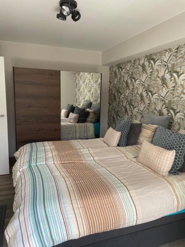 een slaapkamer met een groot bed met een groot hoofdeinde bij Fiets & Zee - Bike & Sea in Oostende
