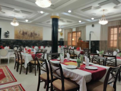 une salle à manger avec tables et chaises et nappes rouges dans l'établissement Le Vallon Vert - Club Equestre, à Azrou