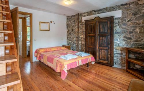 1 dormitorio con cama y pared de piedra en Pet Friendly Home In Loco Di Rovegno With House A Panoramic View, en Carchelli