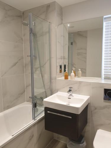 een witte badkamer met een wastafel en een douche bij Coastal Retreat Bognor in Bersted