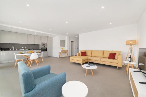 a living room with a couch and chairs and a kitchen at Sunset Views - By SCH in Nazaré