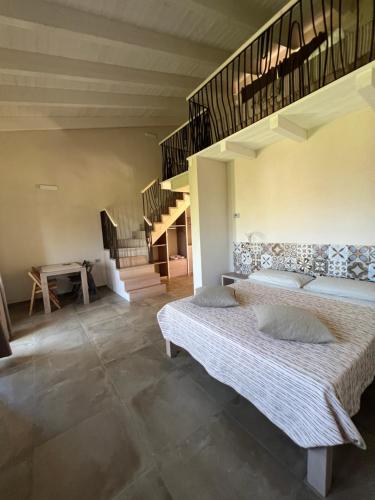 a bedroom with two beds and a staircase at ALELCA DOMO in Buggerru