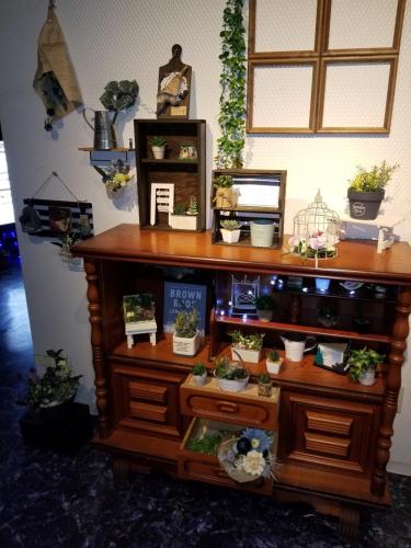 a wooden shelf with potted plants on it at スタイリッシュ-大人専用 in Kameyama
