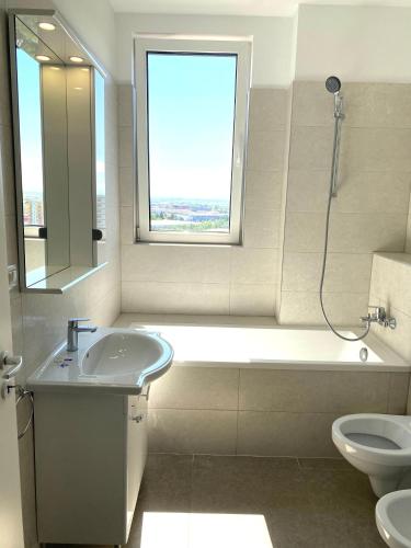 a bathroom with a sink and a tub and a toilet at The Penthouse Rebreanu Towers in Timişoara