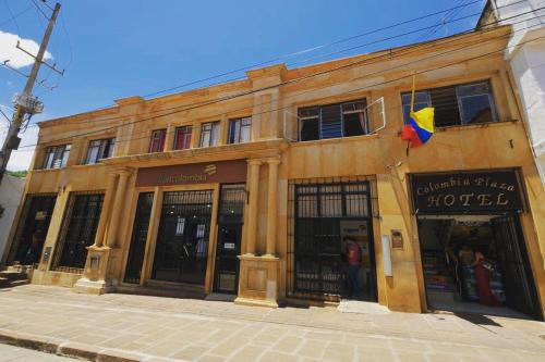 un edificio con una bandera delante de él en San Gil Tours Hostal, en San Gil