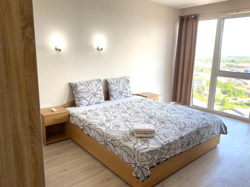 1 dormitorio con cama y ventana grande en The Penthouse Rebreanu Towers, en Timisoara