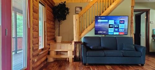 a living room with a blue couch and a staircase at Tobermory Peaceful Private Entire Cottage Log Home Spacious Fully Equipped in Miller Lake