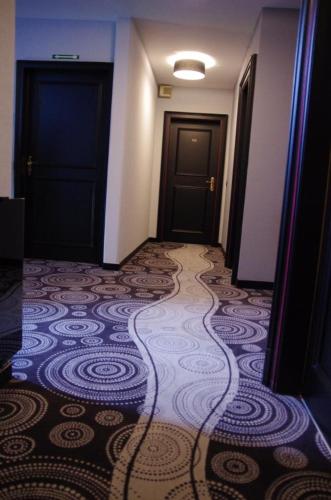a hallway with two doors and a tile floor at Auberge du Cheval Blanc depuis 1785 in Westhalten