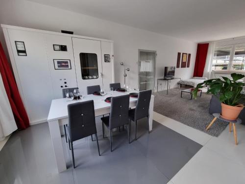 een eetkamer met een witte tafel en stoelen bij Schönes modernes Loft in Essen - Südviertel in Essen