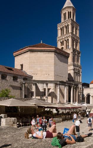 a group of people laying on the ground in front of a building at Palace luxury room in Split