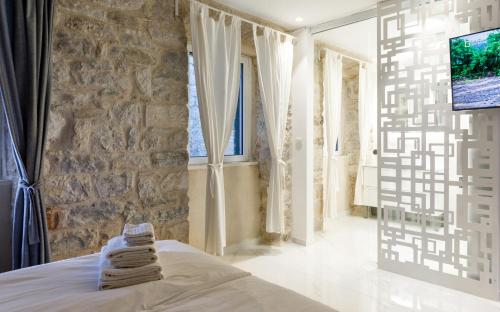 a bedroom with a stone wall and a bed with towels at Palace luxury room in Split