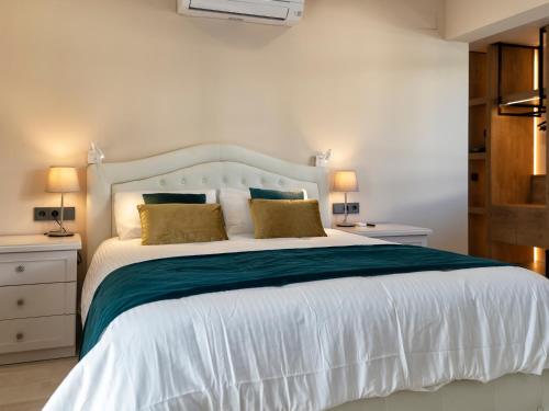 a bedroom with a large white bed with two lamps at Castellpetit in Castelldefels
