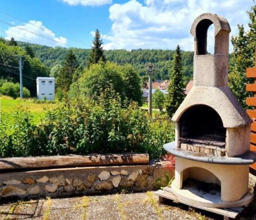 a stone oven in a garden with a view at Doppelzimmer Waldblick in Sonnenbühl
