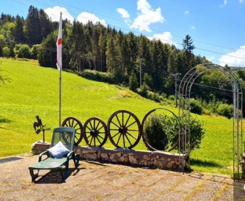 a bench and a flag next to a field at Doppelzimmer Waldblick in Sonnenbühl