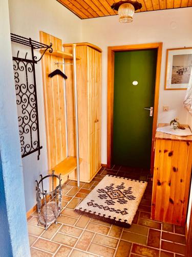 a room with a green door and a tile floor at Doppelzimmer Waldblick in Sonnenbühl