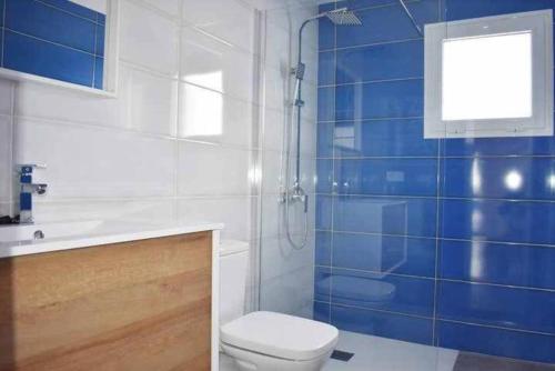 a bathroom with a toilet and a sink and blue tiles at Blue Ocean in Puerto del Carmen