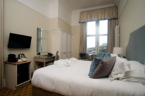 a hotel room with a bed and a television at The Headland Hotel and Spa in Newquay
