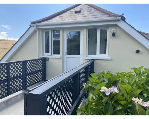 a white house with a black fence and a porch at Higher Upover - Woolacombe-3 Bed-Sleeps 5-TJSHUO in Woolacombe