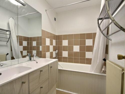 une salle de bain avec un lavabo, une baignoire et un miroir dans l'établissement Appartement 3 pièces au pied des pistes avec balcon, animaux admis - FR-1-455-86, à La Plagne