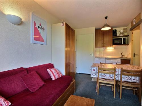 un salon avec un canapé rouge et une cuisine dans l'établissement Appartement 2 pièces au pied des pistes avec terrasse et casiers à skis - FR-1-455-120, à Plagne Villages