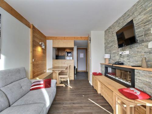 un salon avec un canapé et une cuisine dans l'établissement Spacieux 2 pièces avec accès pistes, terrasse, cheminée et parking - FR-1-455-147, à Aime La Plagne