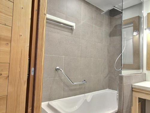 une salle de bain avec une baignoire blanche et une douche dans l'établissement Spacieux 2 pièces avec accès pistes, terrasse, cheminée et parking - FR-1-455-147, à Aime La Plagne