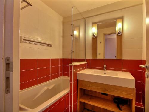 une salle de bain avec un lavabo, une baignoire et un miroir dans l'établissement Duplex moderne proche pistes, balcon, cuisine équipée, pour 7 pers - FR-1-455-181, à La Plagne Tarentaise