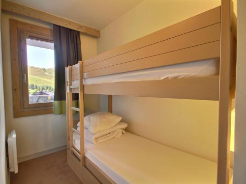 une chambre avec deux lits superposés et une fenêtre dans l'établissement Studio-cabine pour 4 avec balcon, proche pistes et commerces - FR-1-455-198, à La Plagne Tarentaise