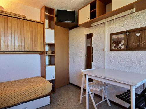 Cette petite chambre comprend une table et un lit. dans l'établissement Studio au pied des pistes avec vue Mont-Blanc - FR-1-455-161, à La Plagne