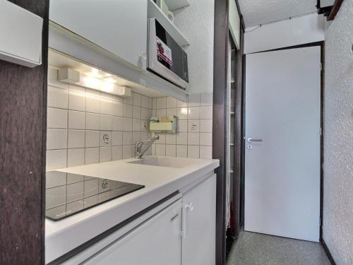 - une cuisine blanche avec un évier et un miroir dans l'établissement Studio au pied des pistes avec vue Mont-Blanc - FR-1-455-161, à La Plagne