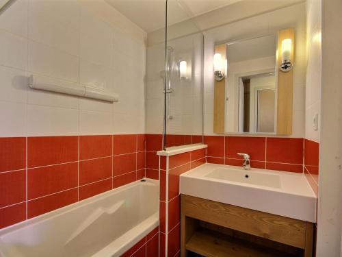une salle de bain avec un lavabo, une baignoire et un miroir dans l'établissement Joli studio-cabine pour 4 à Belle Plagne avec balcon et accès aux pistes - FR-1-455-201, à La Plagne Tarentaise