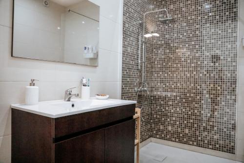 un bagno con lavandino e doccia di Rest House - Vila do Conde a Vila do Conde